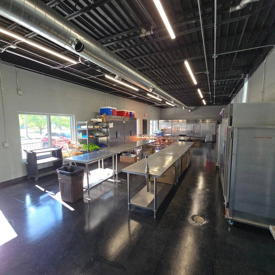 Wide view down the kitchen showing prep tables and equipment